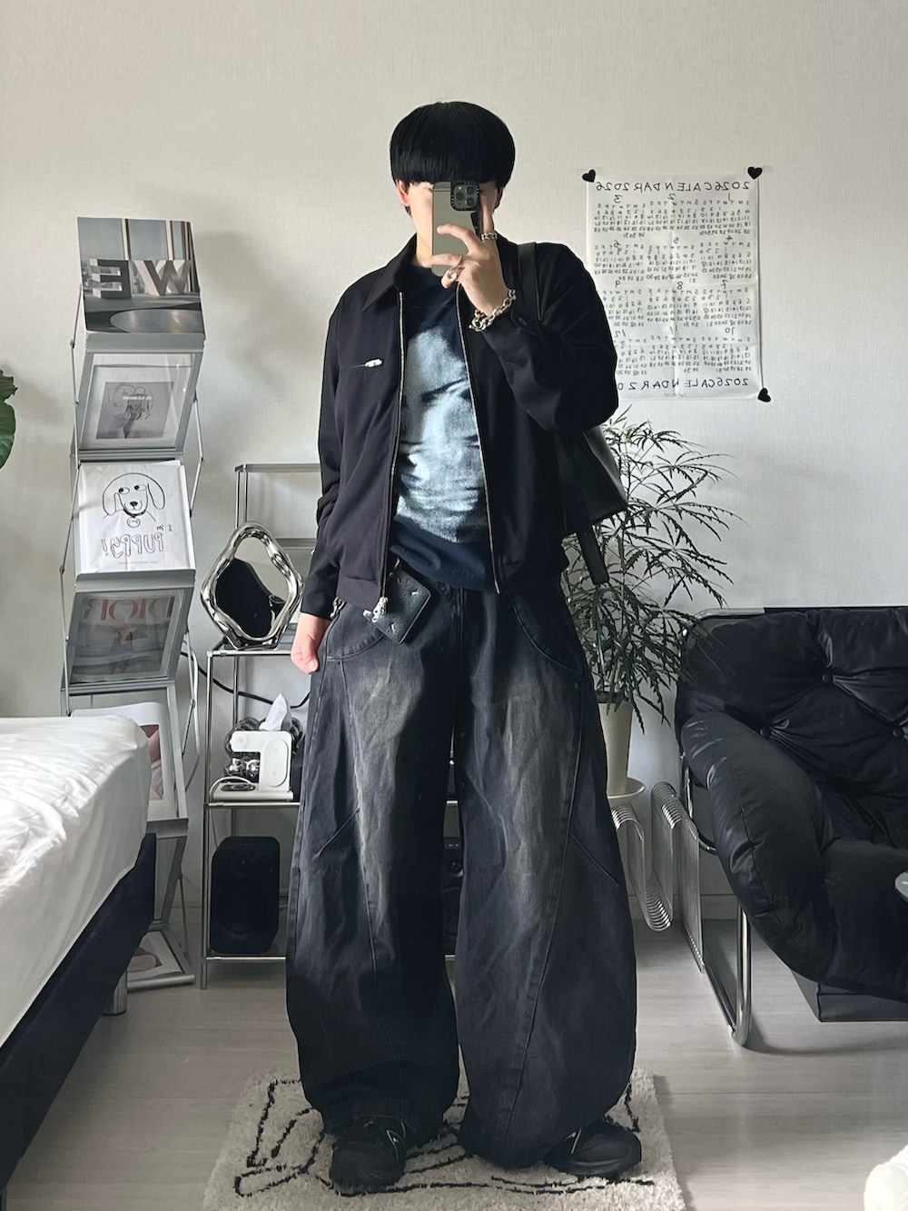 ブラック系のブルゾン、ブルー系のTシャツ/カットソー、ブラック系のデニムパンツを着用したメンズの春コーディネートの2枚目の写真