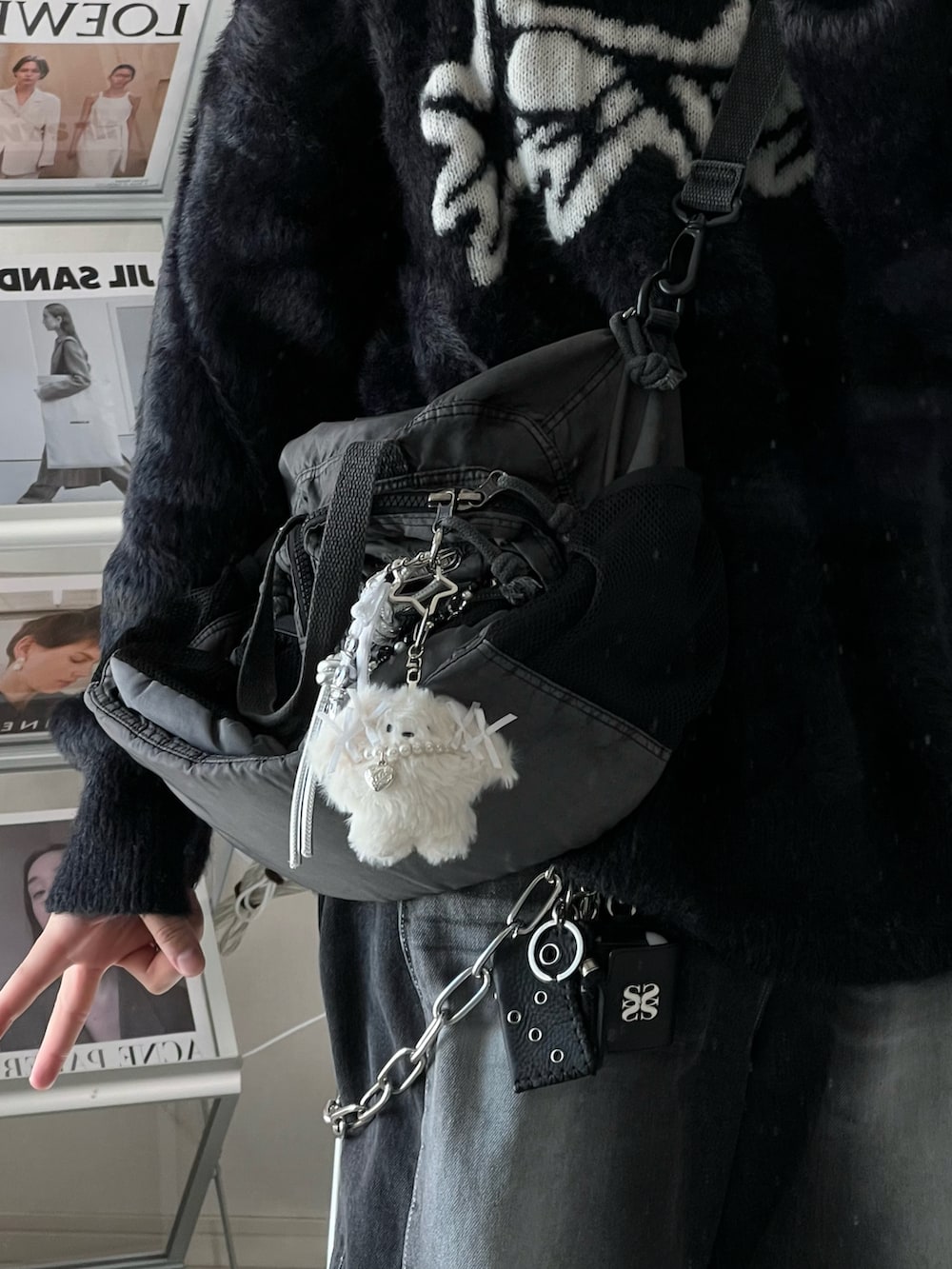 ブラック系のデニムパンツ、ブラック系のスリッポン、グレー系のショルダーバッグを着用したメンズの冬コーディネートの4枚目の写真