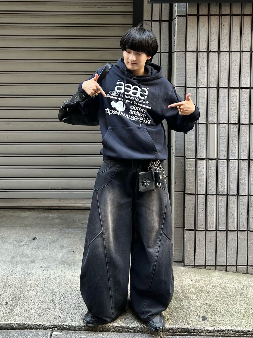 ブルー系のスウェット、ブラック系のデニムパンツ、ブラック系のスニーカーを着用したメンズの秋コーディネートの2枚目の写真