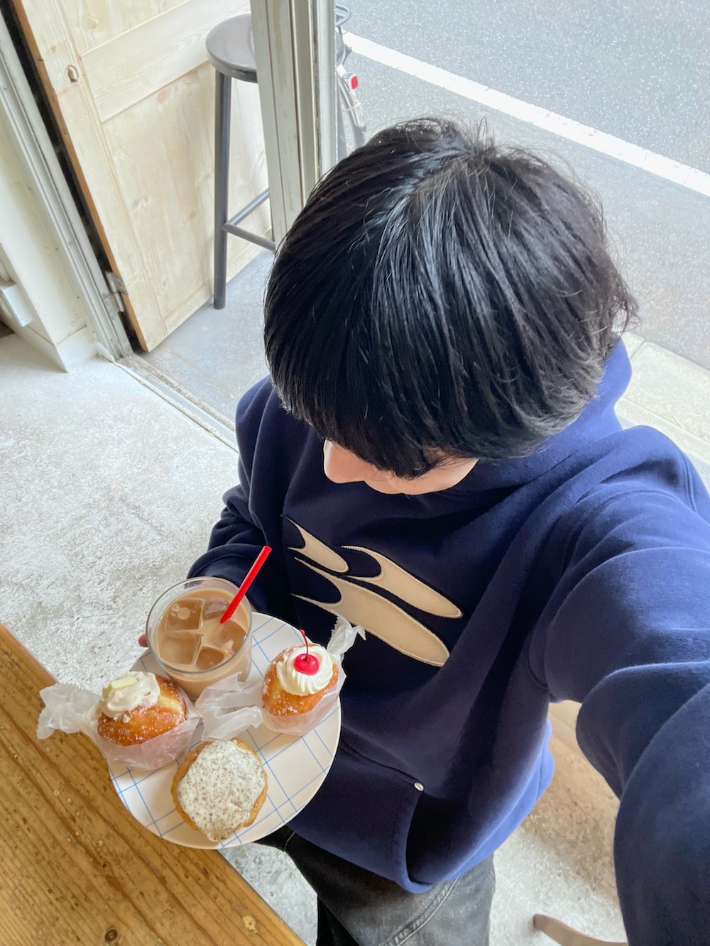 ブルー系のパーカー、グレー系のショルダーバッグ、ブラック系のデニムパンツを着用したメンズの秋コーディネートの3枚目の写真