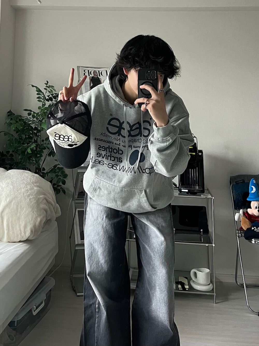 グレー系のパーカー、ブラック系のデニムパンツ、ブラック系のキャップを着用したメンズの秋コーディネートの3枚目の写真