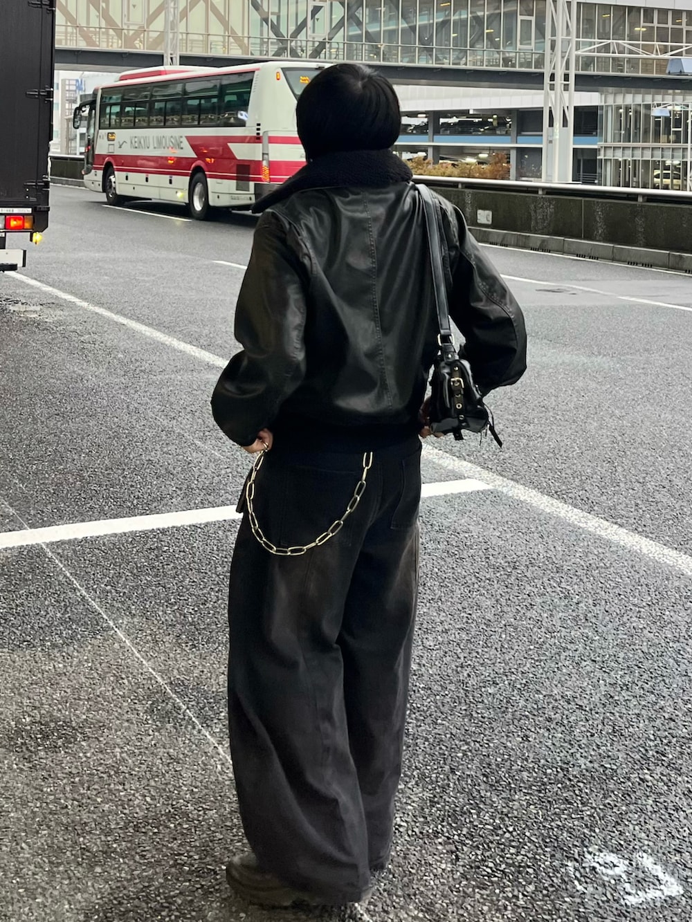 ブラック系のデニムパンツ、ブラック系のブルゾン、ブラック系のショルダーバッグを着用したメンズの秋コーディネートの3枚目の写真