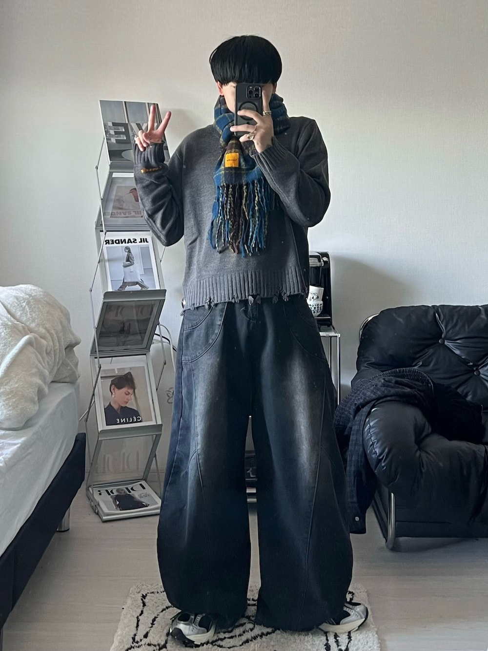 グレー系のニット/セーター、ブラック系のデニムパンツ、ブラック系のスニーカーを着用したメンズの秋コーディネートの3枚目の写真