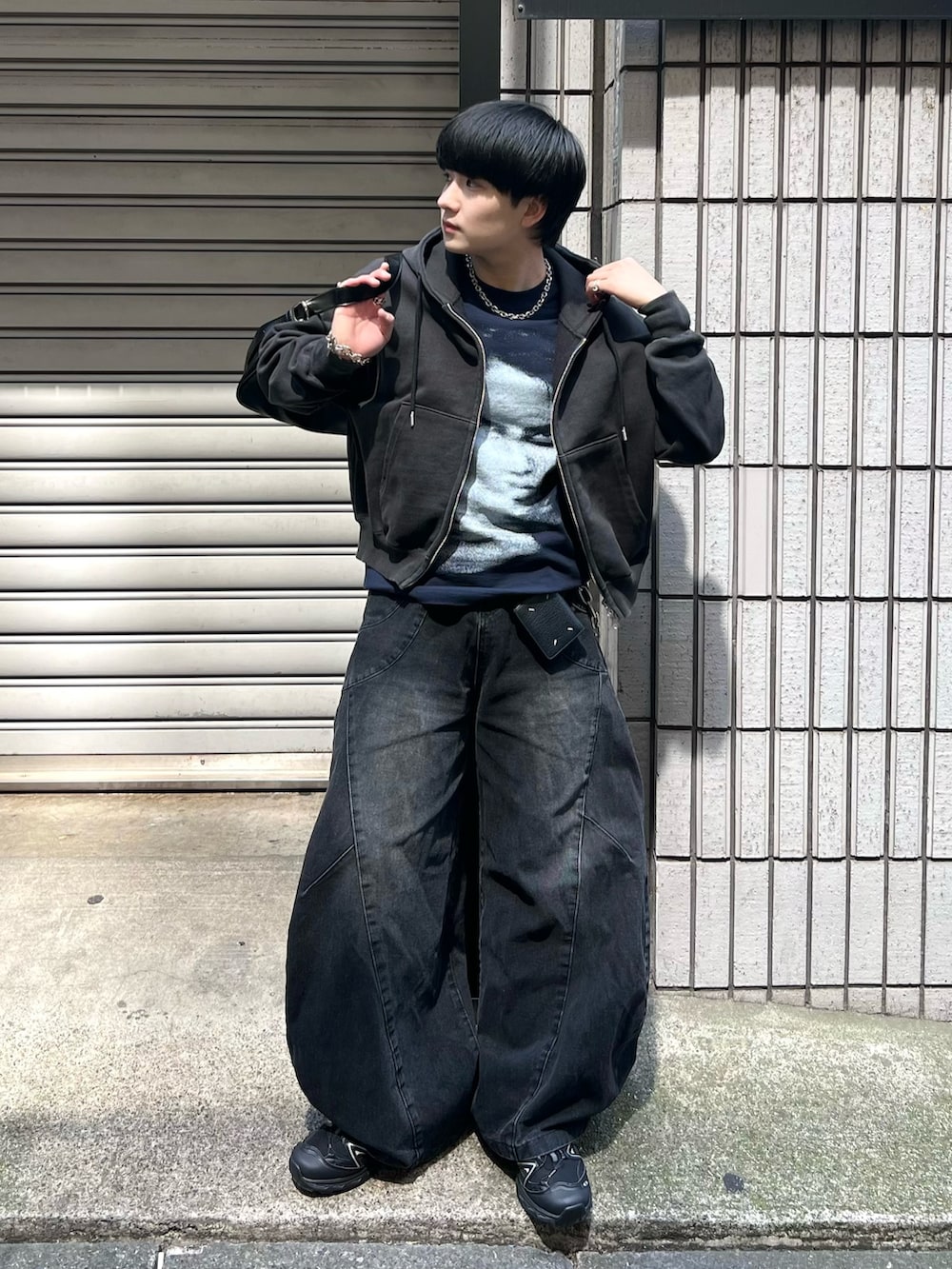 ブラック系のデニムパンツ、ブラック系のパーカー、ブルー系のTシャツ/カットソーを着用したメンズの春コーディネートの2枚目の写真