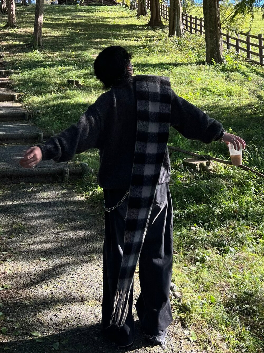 グレー系のニット/セーター、ブラック系のデニムパンツ、ブラック系のブーツを着用したメンズの冬コーディネートの2枚目の写真