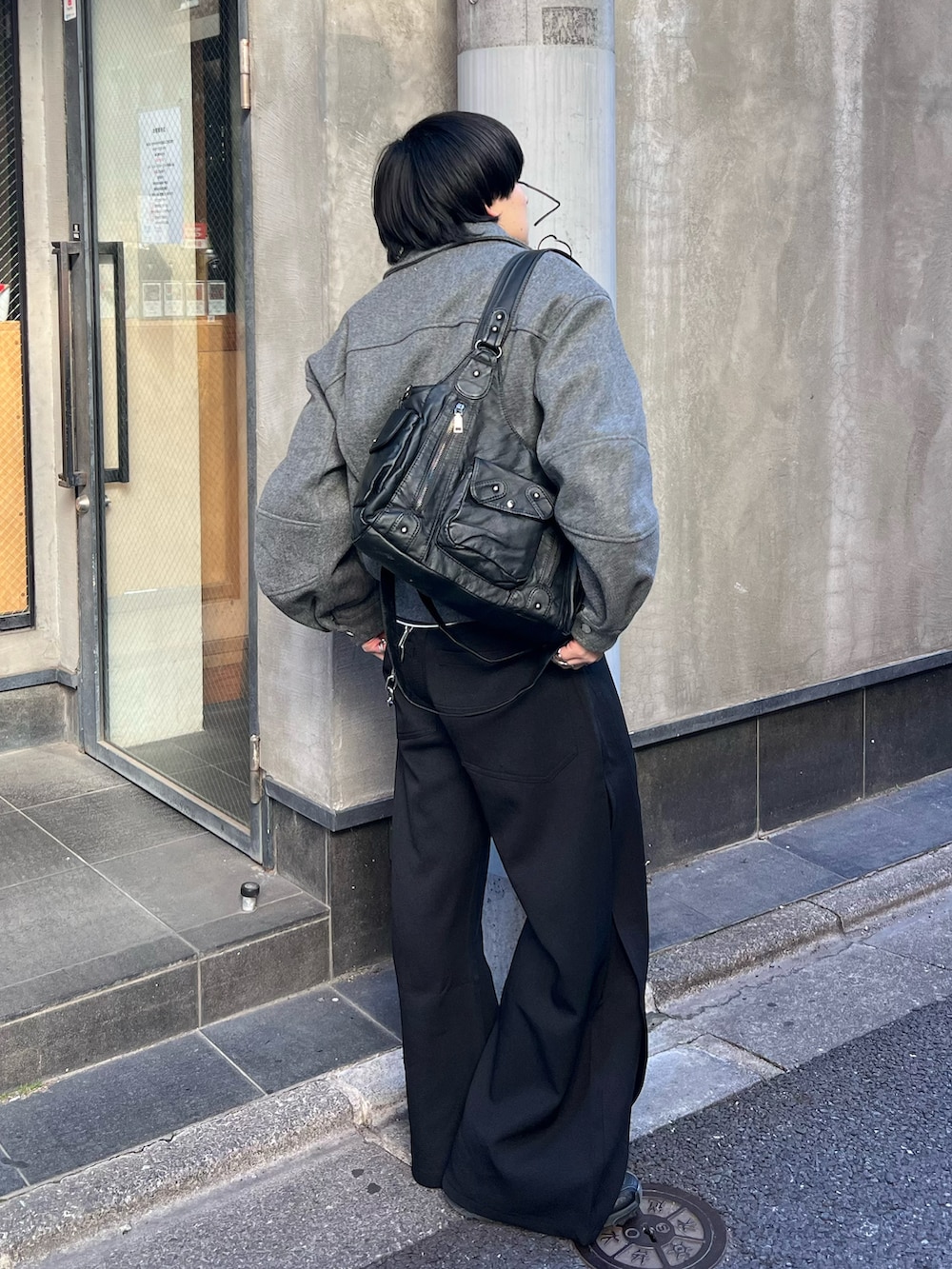 ブラック系のTシャツ/カットソー、グレー系のブルゾン、ブラック系のスラックスを着用したメンズの冬コーディネートの2枚目の写真