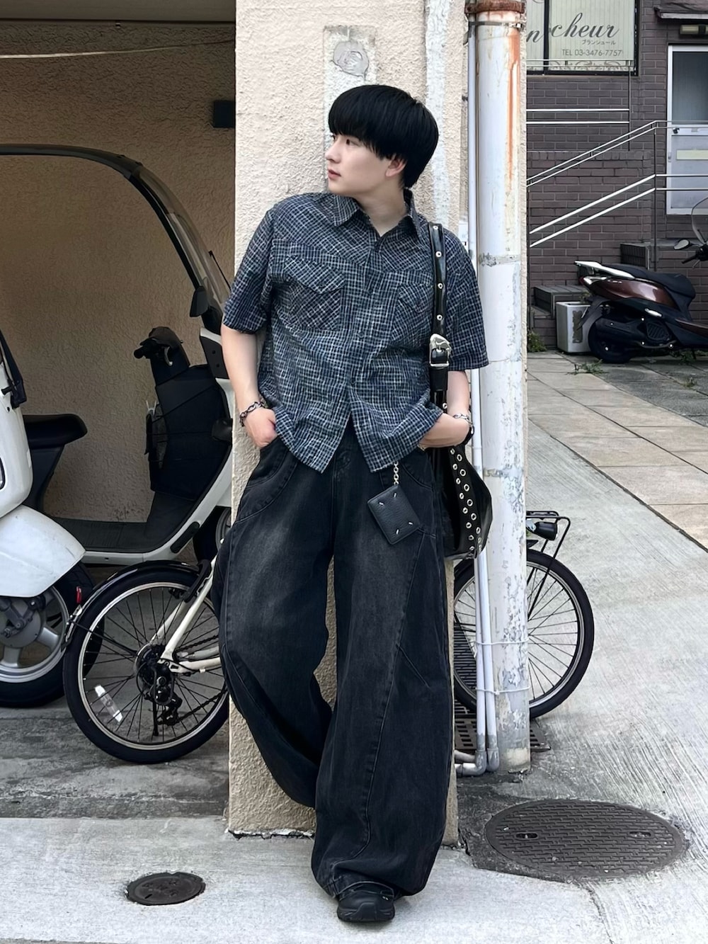 ブラック系のデニムパンツ、ブルー系のシャツ/ブラウス、ブラック系のショルダーバッグを着用したメンズの夏コーディネートの2枚目の写真
