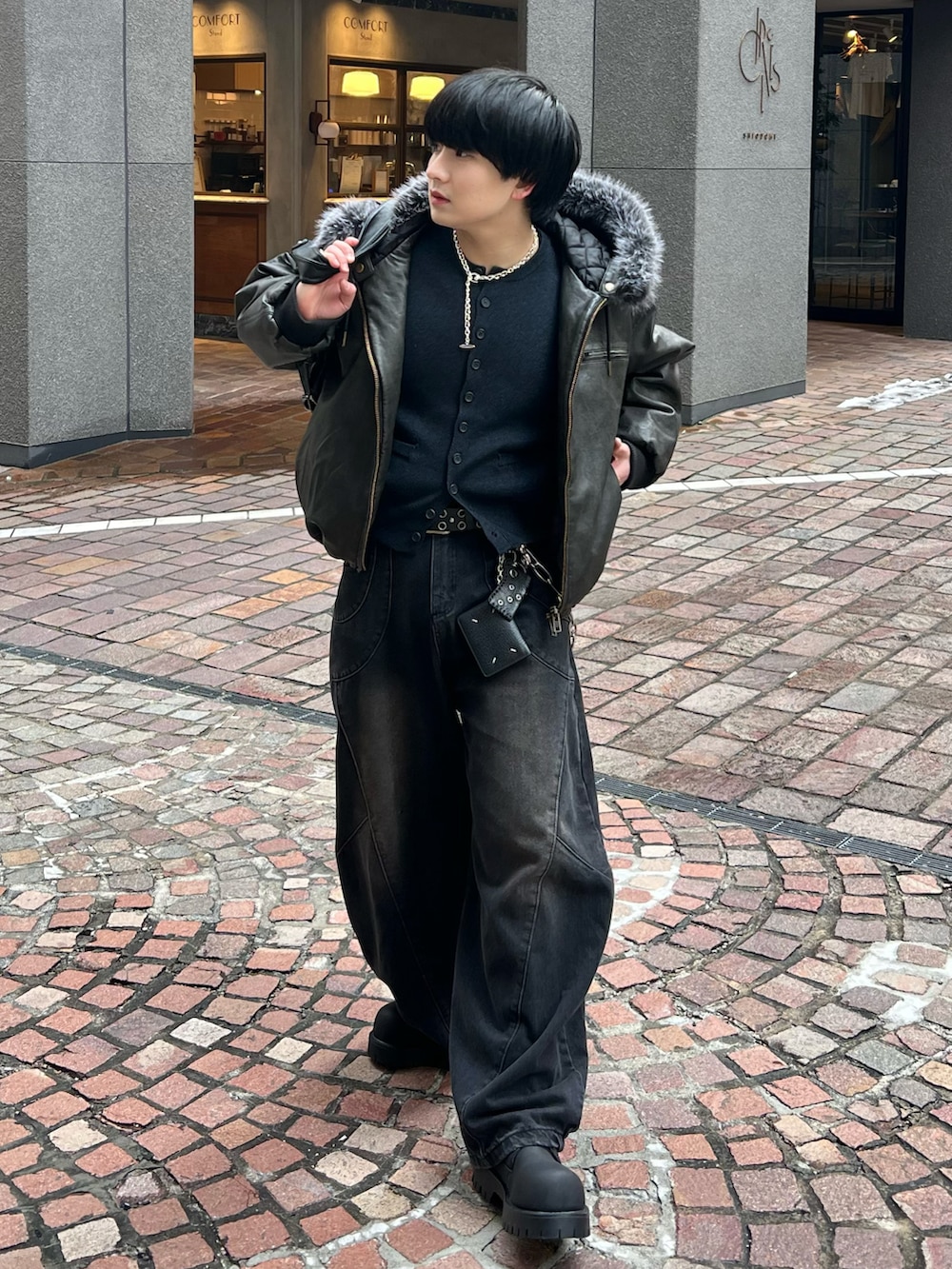 ブラック系のカーディガン/ボレロ、ブラック系のデニムパンツ、ブラック系のブーツを着用したメンズの冬コーディネートの2枚目の写真