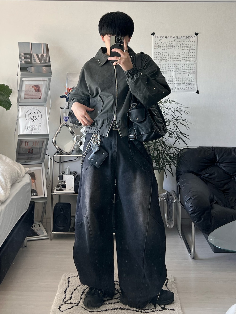 ブラック系のブルゾン、ブラック系のデニムパンツ、ブラック系のスニーカーを着用したメンズの春コーディネートの2枚目の写真