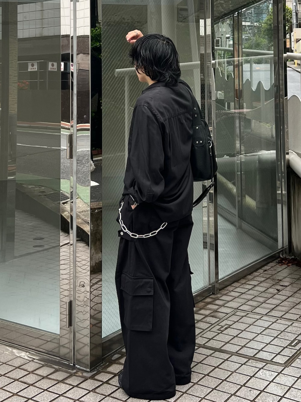 ブラック系のシャツ/ブラウス、ブラック系のカーゴパンツ、ブラック系のスニーカーを着用したメンズの春コーディネートの3枚目の写真