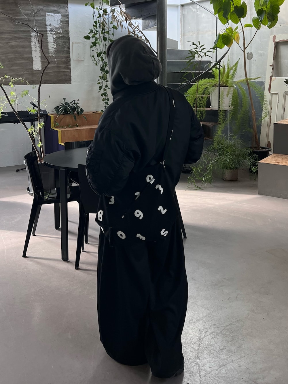 ブラック系のパーカー、ブラック系のTシャツ/カットソー、ブラック系のスラックスを着用したメンズの冬コーディネートの2枚目の写真