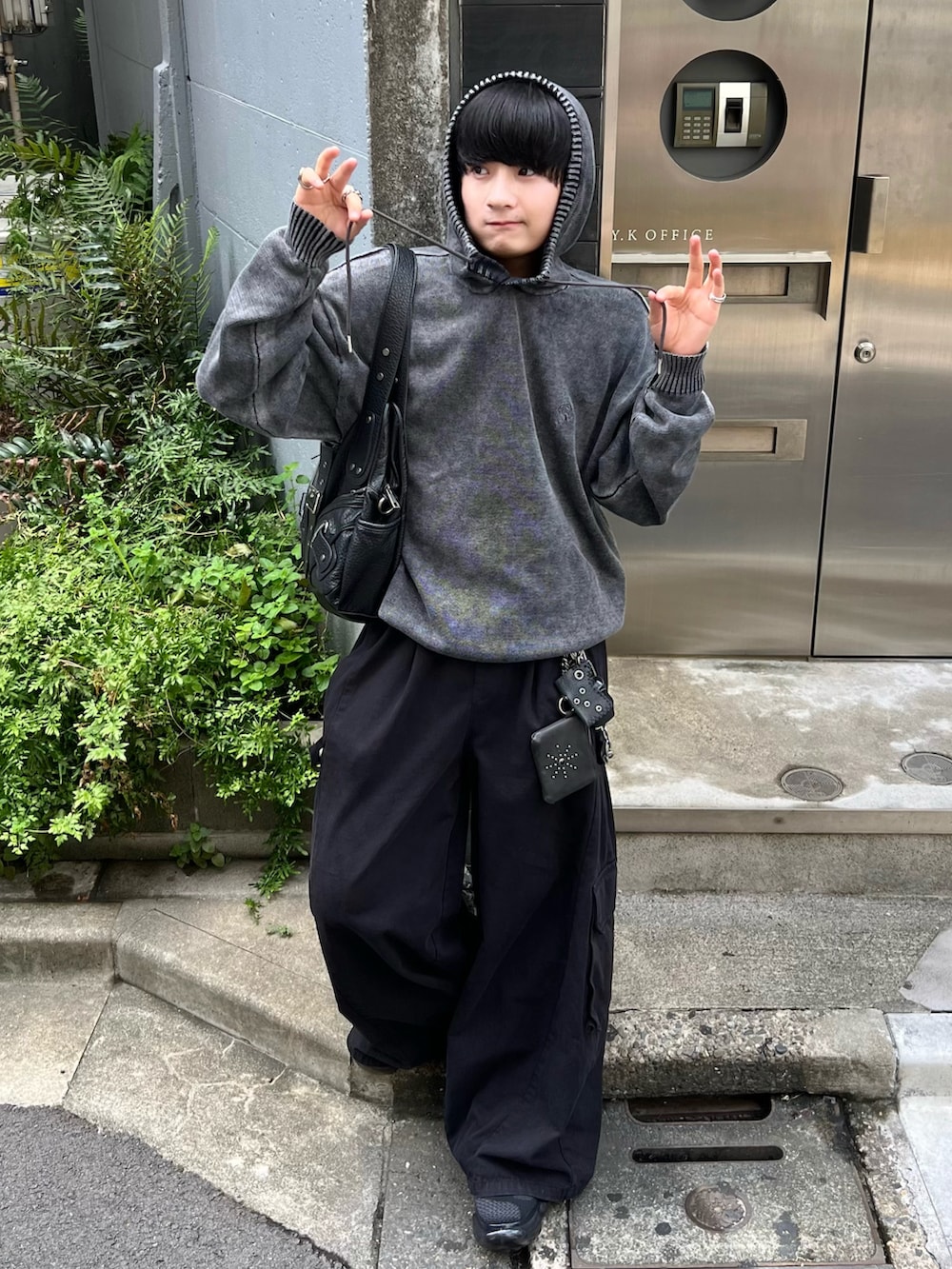 ブラック系のパーカー、ブラック系のカーゴパンツ、ブラック系のスニーカーを着用したメンズの夏コーディネートの2枚目の写真