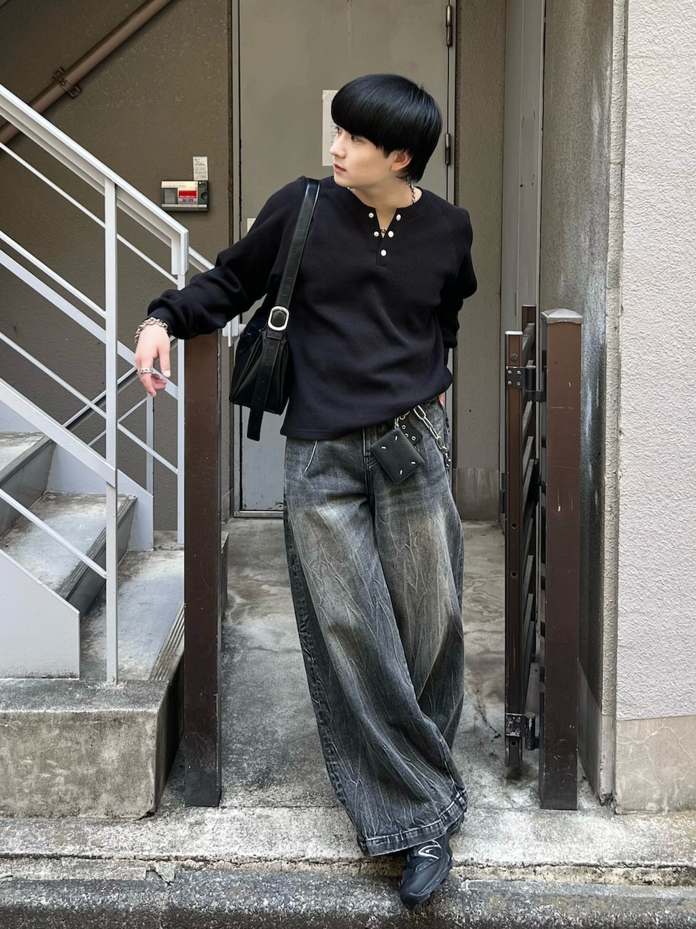 ブラック系のTシャツ/カットソー、ブラック系のデニムパンツ、ブラック系のショルダーバッグを着用したメンズの春コーディネートの2枚目の写真