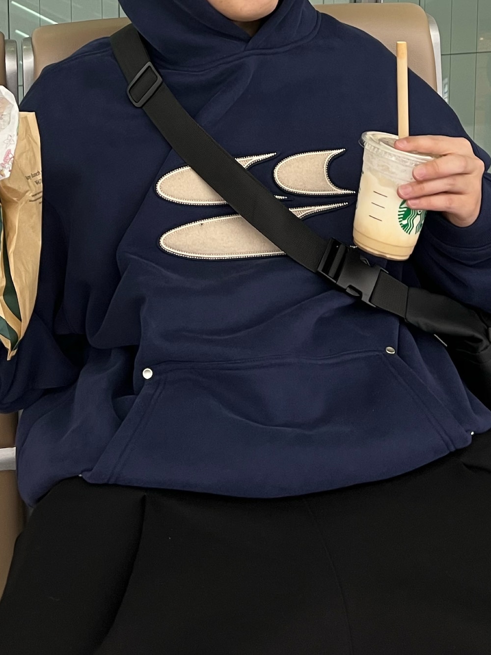 ブルー系のパーカー、グレー系のショルダーバッグ、ブラック系のスニーカーを着用したメンズの春コーディネートの3枚目の写真