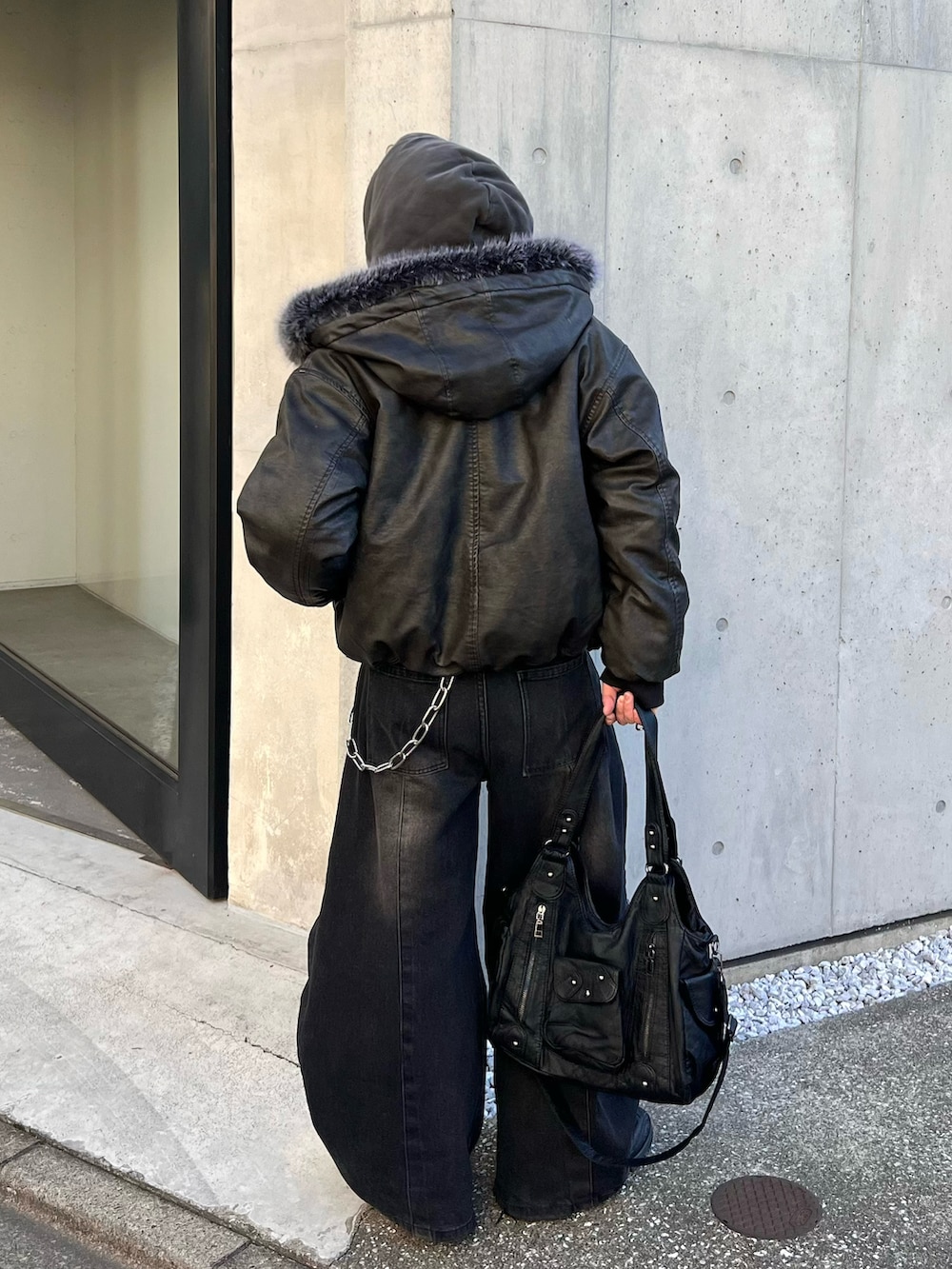 ブラック系のデニムパンツ、ブラック系のブルゾン、ブラック系のパーカーを着用したメンズの冬コーディネートの2枚目の写真