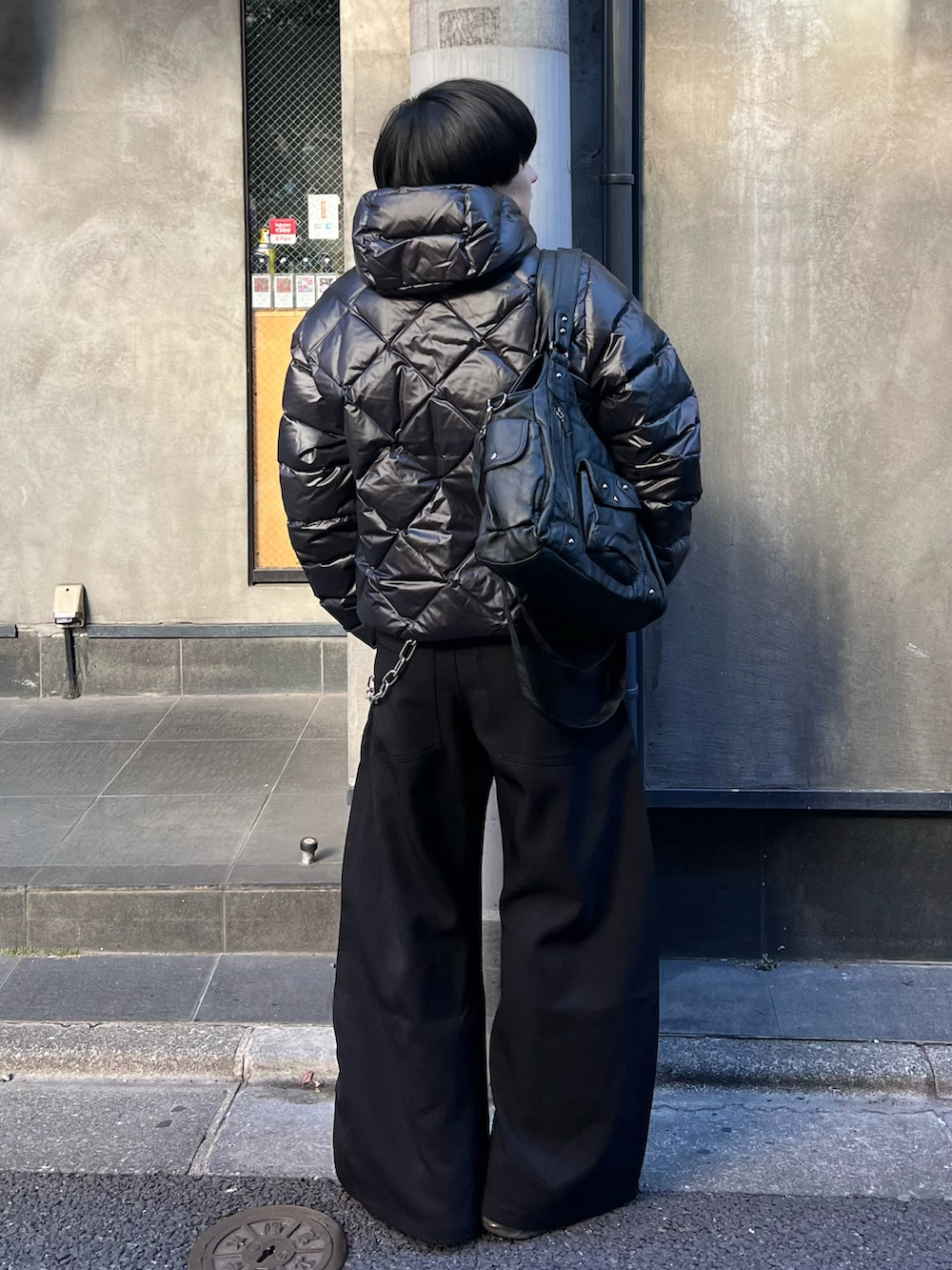 ブラック系のダウンジャケット/コート、ブラック系のスラックス、ブラック系のショルダーバッグを着用したメンズの冬コーディネートの3枚目の写真