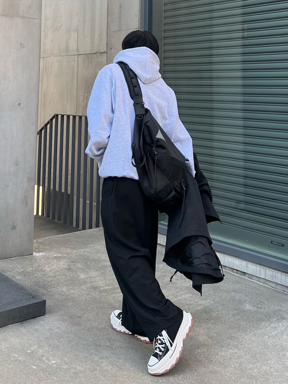 グレー系のパーカー、ブラック系のその他アウター、ブラック系のその他パンツを着用したメンズの秋コーディネートの3枚目の写真