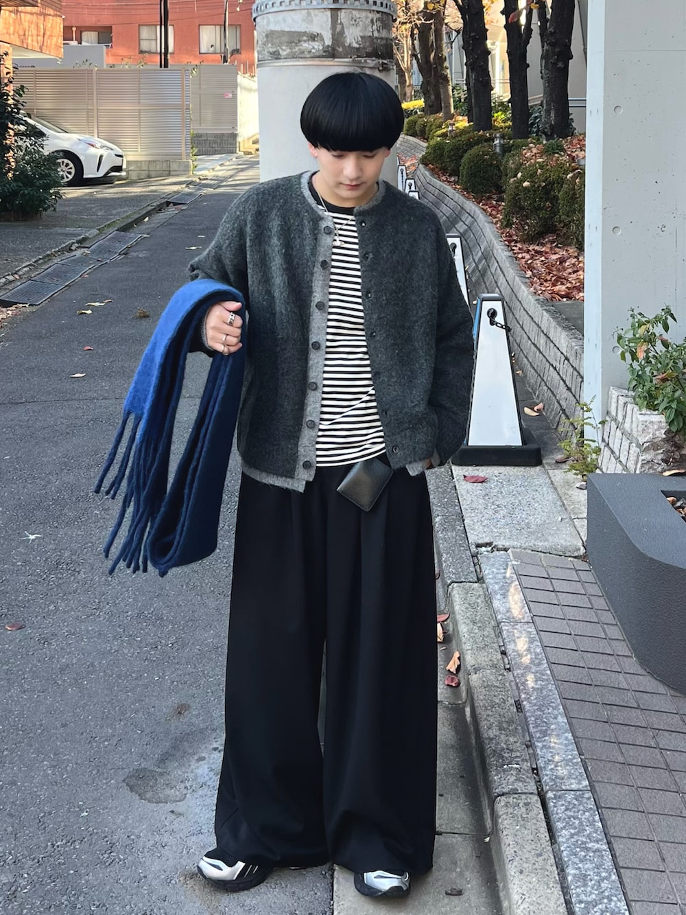 グレー系のカーディガン/ボレロ、ブラック系のTシャツ/カットソー、ブラック系のスラックスを着用したメンズの冬コーディネートの2枚目の写真