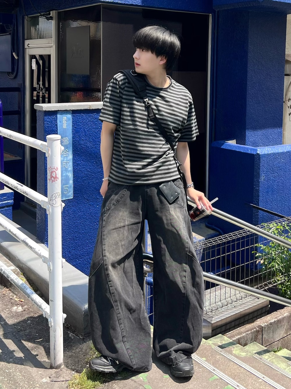 ブラック系のデニムパンツ、ブラック系のTシャツ/カットソー、ブラック系のショルダーバッグを着用したメンズの春コーディネートの2枚目の写真