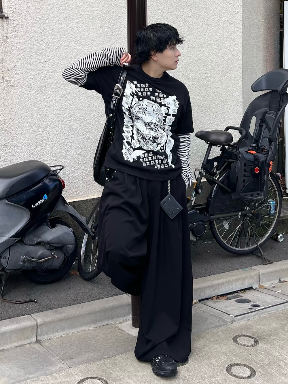 ブラック系のスラックス、ブラック系のTシャツ/カットソー、ホワイト系のTシャツ/カットソーを着用したメンズの秋コーディネートの2枚目の写真