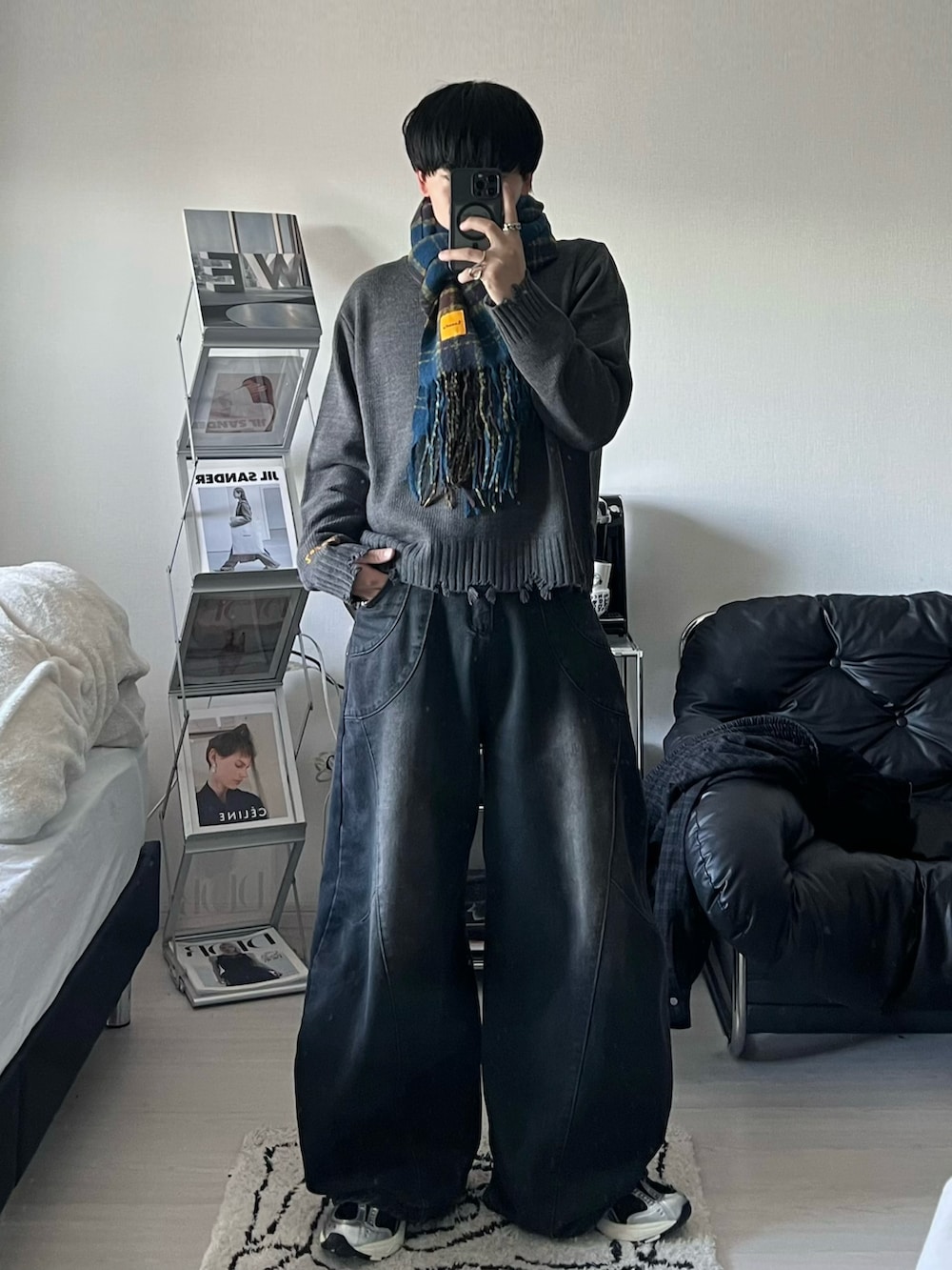 グレー系のニット/セーター、ブラック系のデニムパンツ、ブラック系のスニーカーを着用したメンズの秋コーディネートの2枚目の写真