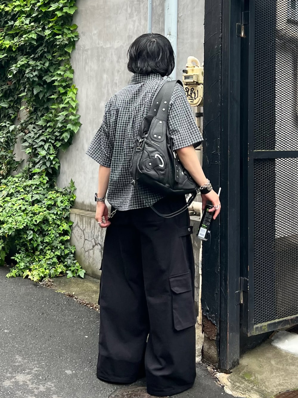 ブラック系のシャツ/ブラウス、ブラック系のカーゴパンツ、ブラック系のスニーカーを着用したメンズの春コーディネートの2枚目の写真