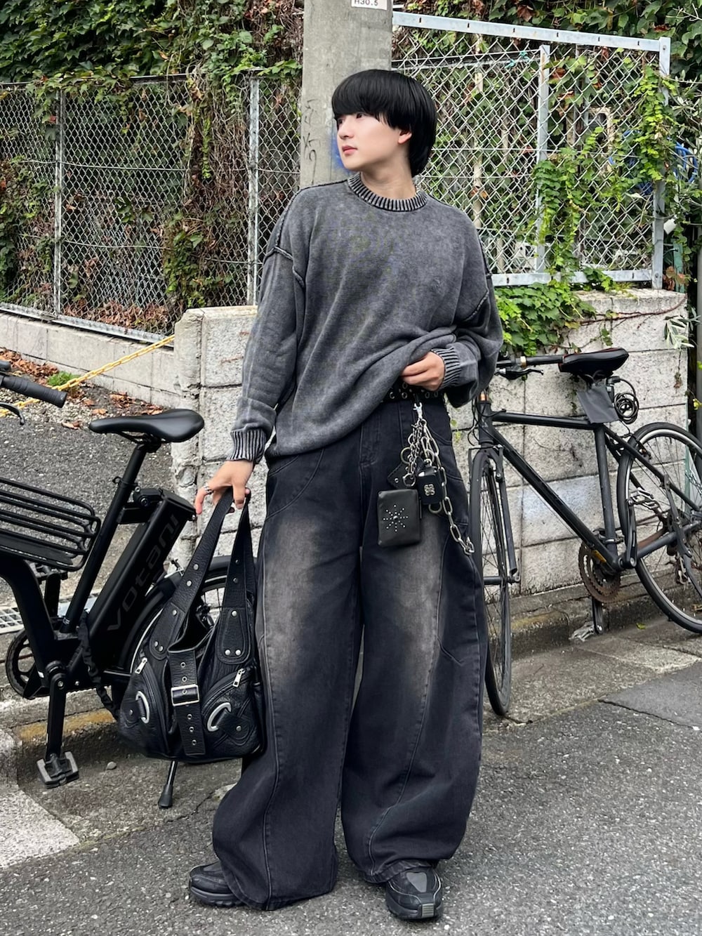 ブラック系のデニムパンツ、ブラック系のニット/セーター、ブラック系のショルダーバッグを着用したメンズの夏コーディネートの3枚目の写真