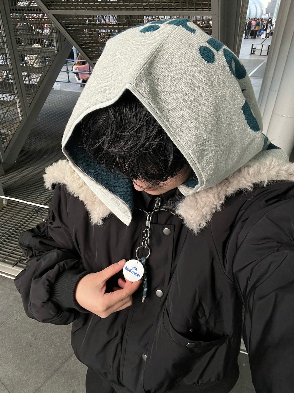 ブラック系のブルゾン、グレー系のデニムジャケット、ブラック系のスラックスを着用したメンズの冬コーディネートの3枚目の写真