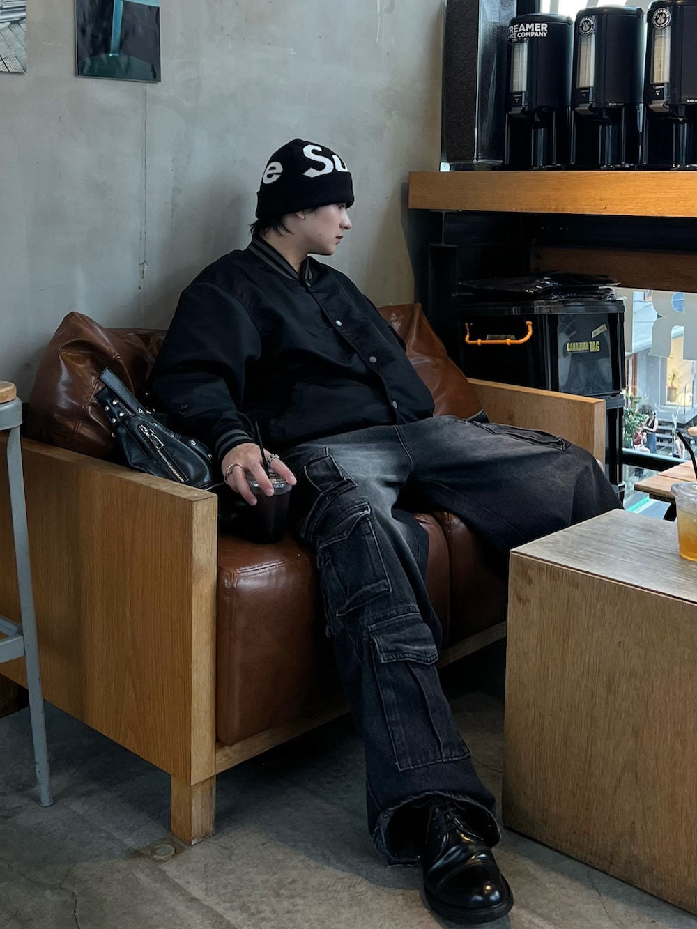 ブラック系のブルゾン、ブラック系のショルダーバッグ、ブラック系のデニムパンツを着用したメンズの秋コーディネートの2枚目の写真