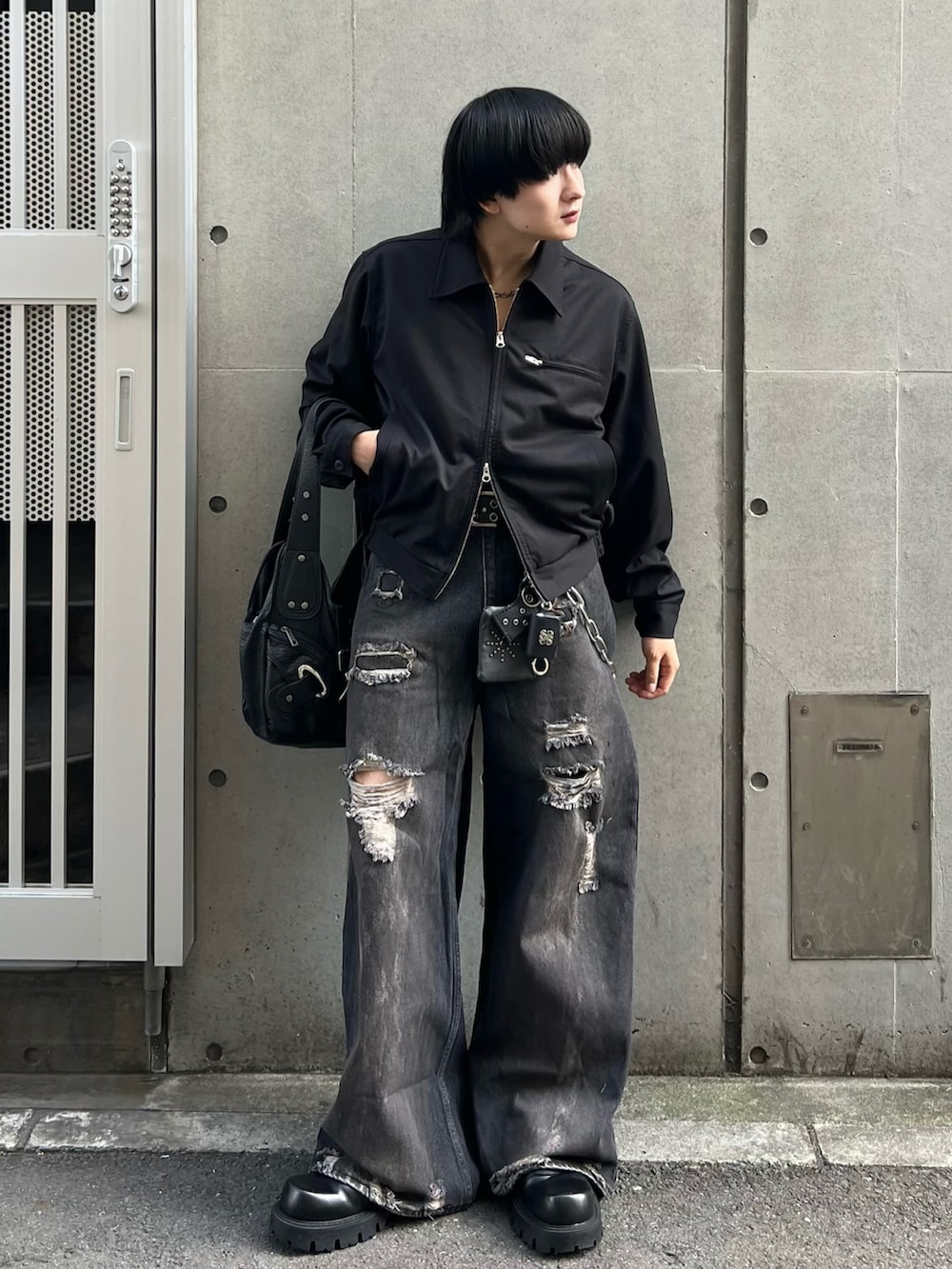 ブラック系のデニムパンツ、ブラック系のブルゾン、ブラック系のショルダーバッグを着用したメンズの秋コーディネートの2枚目の写真