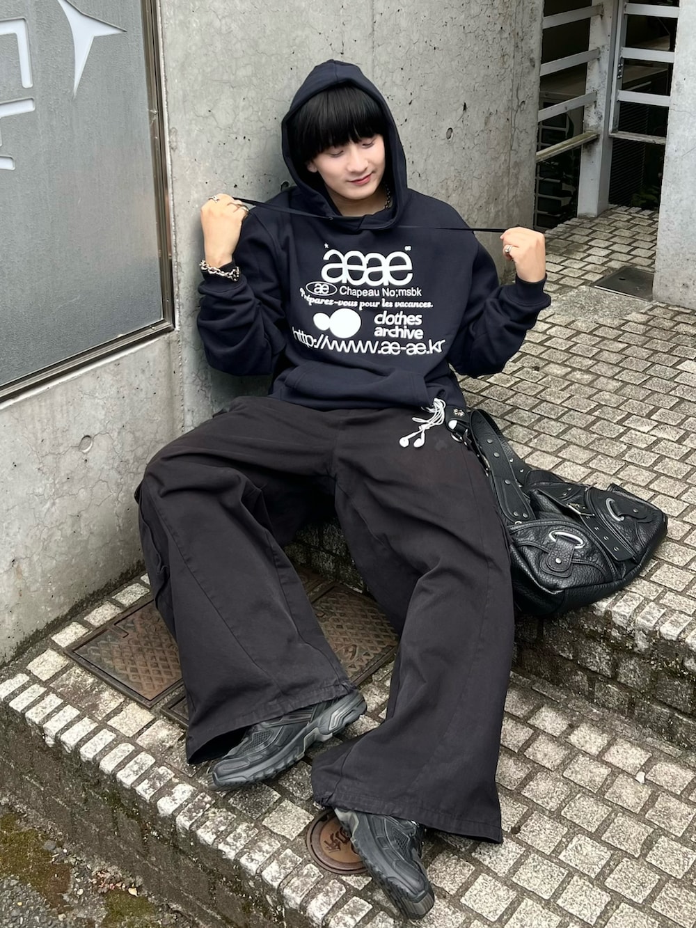 ブルー系のスウェット、ブラック系のカーゴパンツ、ブラック系のショルダーバッグを着用したメンズの秋コーディネートの2枚目の写真