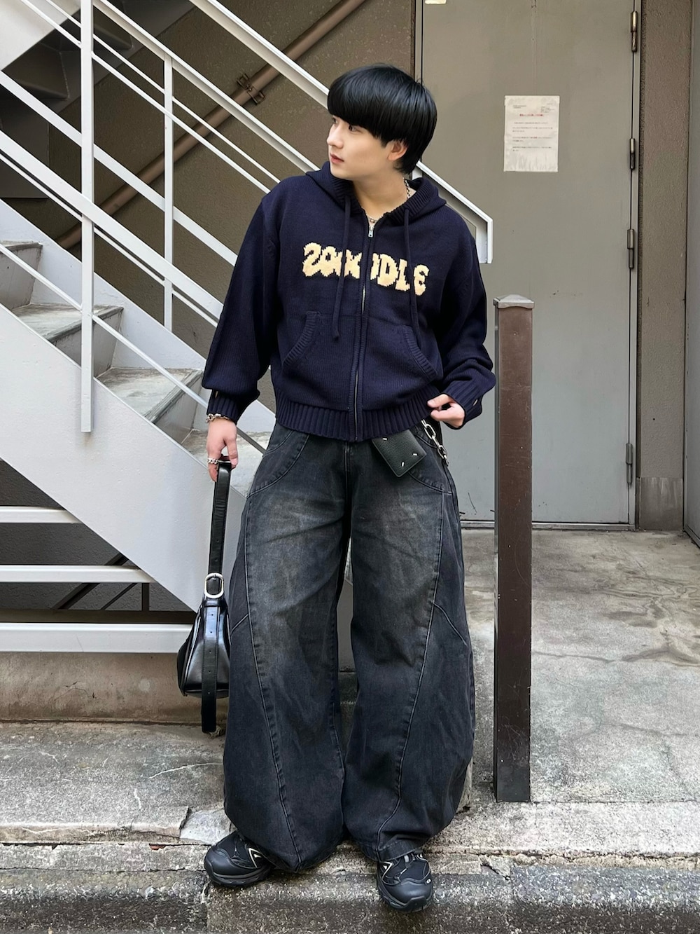 ブラック系のデニムパンツ、レッド系のパーカー、ブラック系のショルダーバッグを着用したメンズの春コーディネートの2枚目の写真