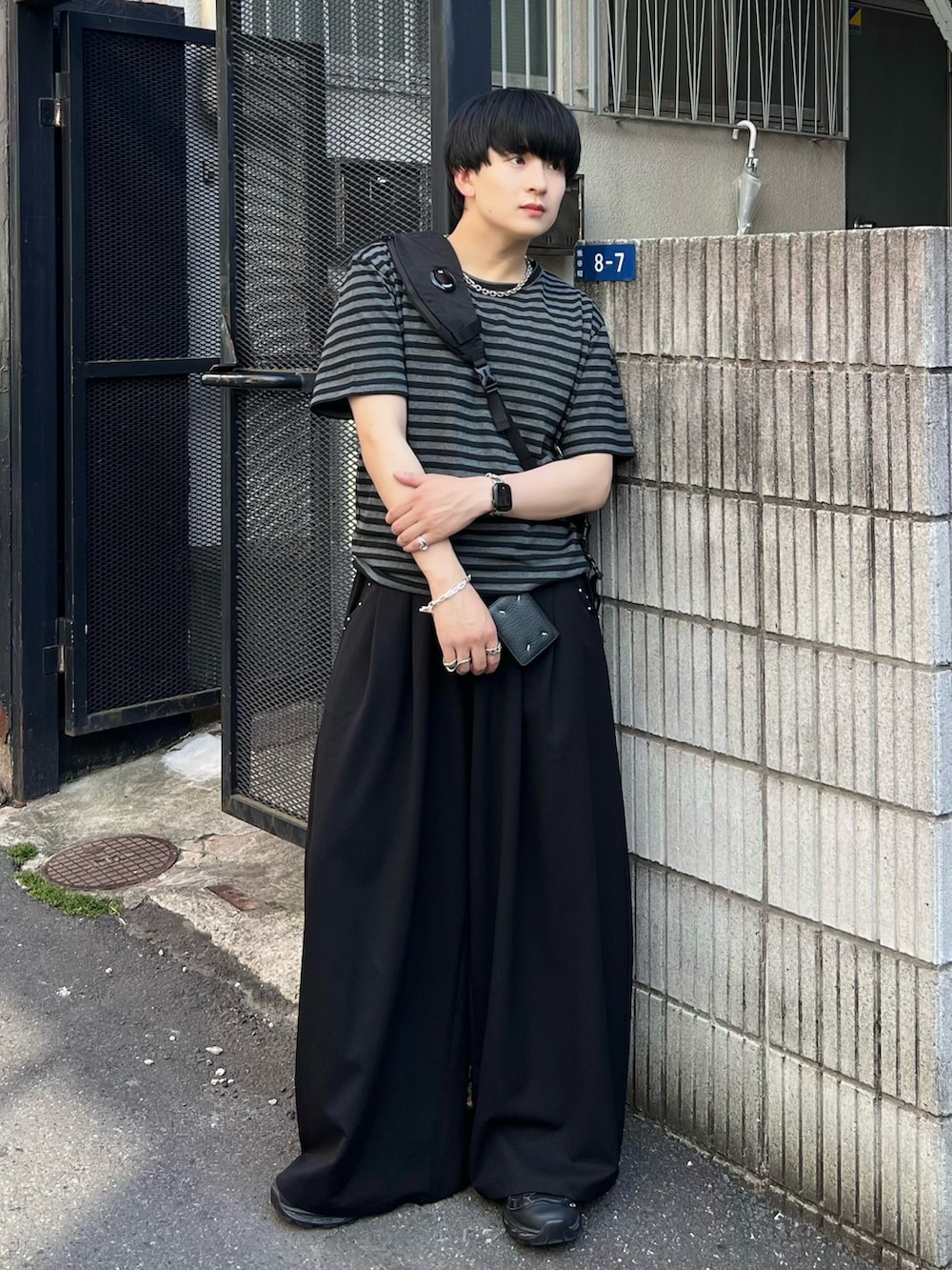 ブラック系のTシャツ/カットソー、ブラック系のスラックス、ブラック系のショルダーバッグを着用したメンズの夏コーディネートの2枚目の写真