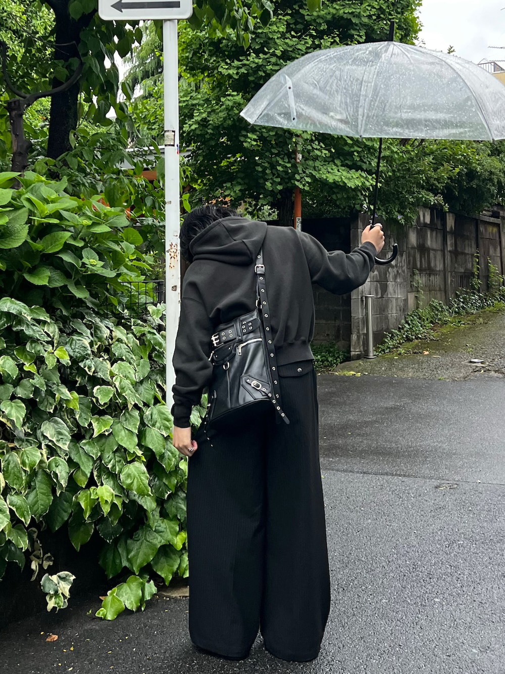 ブラック系のスラックス、ブラック系のパーカー、ブラック系のショルダーバッグを着用したメンズの春コーディネートの3枚目の写真