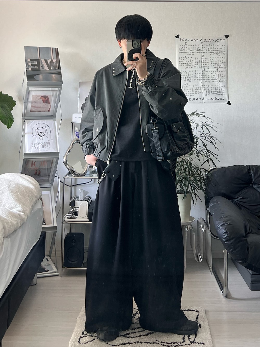 ブラック系のブルゾン、ブラック系のスラックス、ブラック系のTシャツ/カットソーを着用したメンズの春コーディネートの2枚目の写真