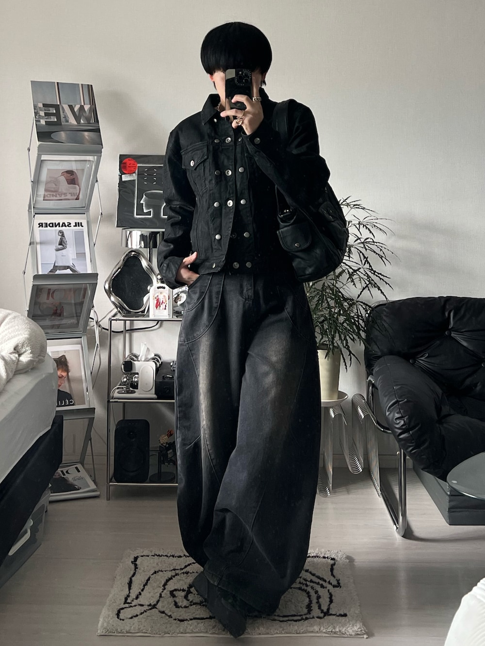 ブラック系のデニムジャケット、ブラック系のデニムパンツ、ブラック系のスニーカーを着用したメンズの冬コーディネートの2枚目の写真