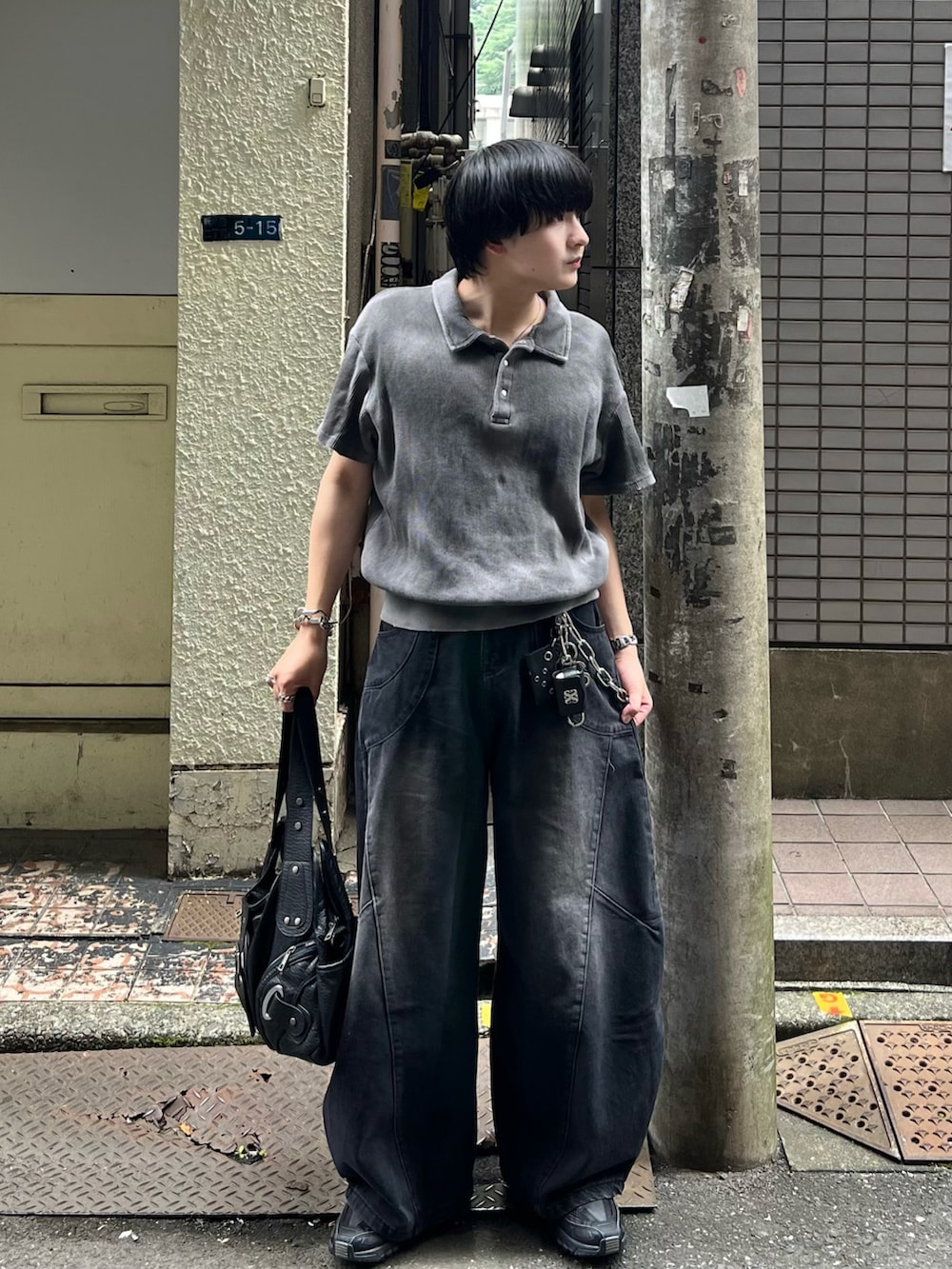 グレー系のポロシャツ、ブラック系のデニムパンツ、ブラック系のショルダーバッグを着用したメンズの夏コーディネートの2枚目の写真