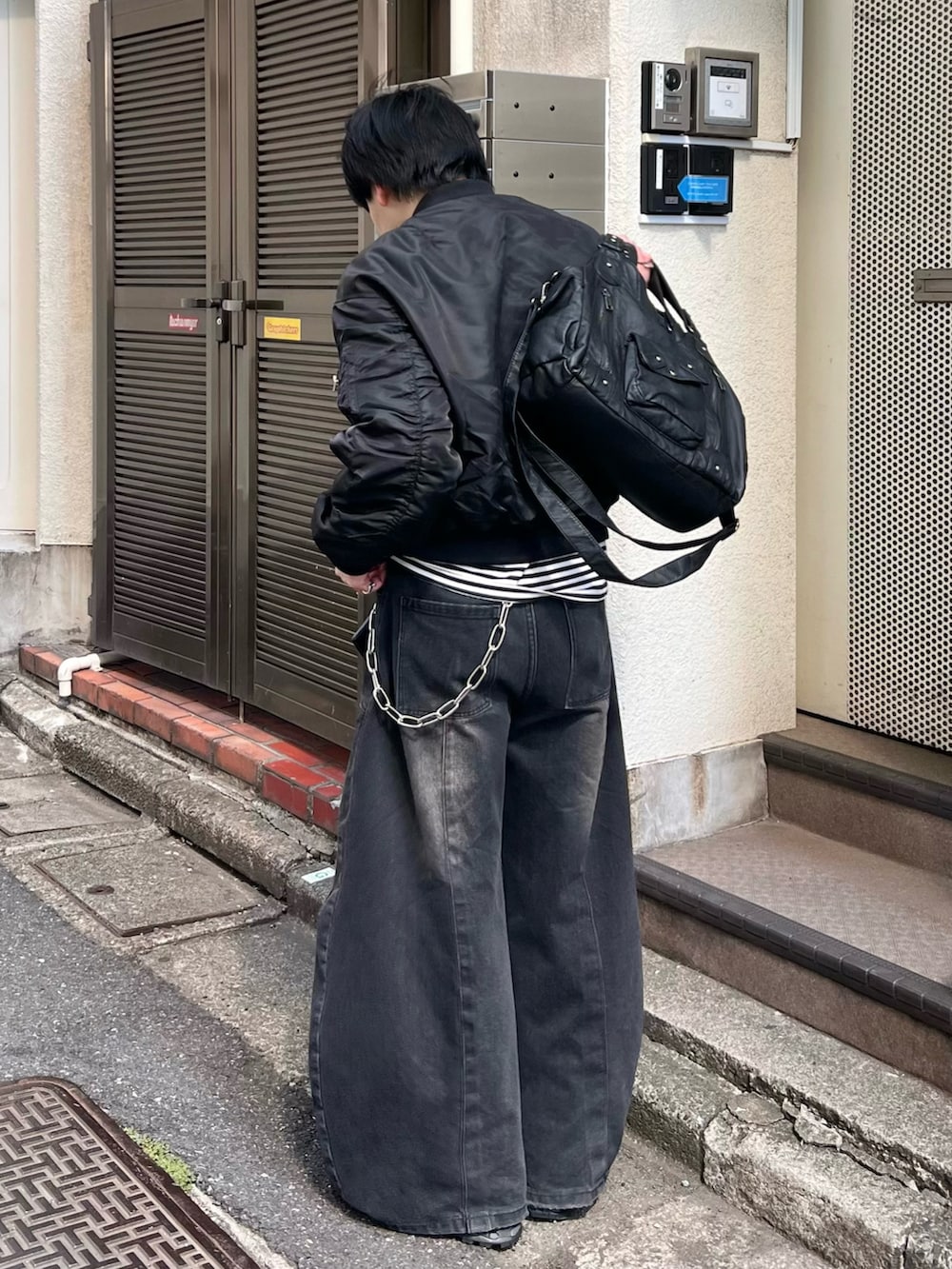 ブラック系のMA-1、ブラック系のTシャツ/カットソー、ブラック系のデニムパンツを着用したメンズの春コーディネートの2枚目の写真