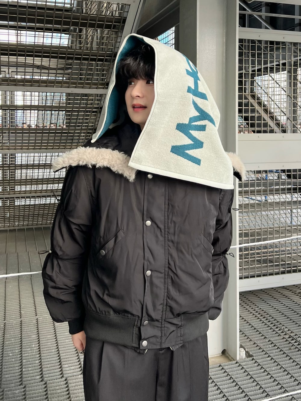 ブラック系のブルゾン、グレー系のデニムジャケット、ブラック系のスラックスを着用したメンズの冬コーディネートの2枚目の写真