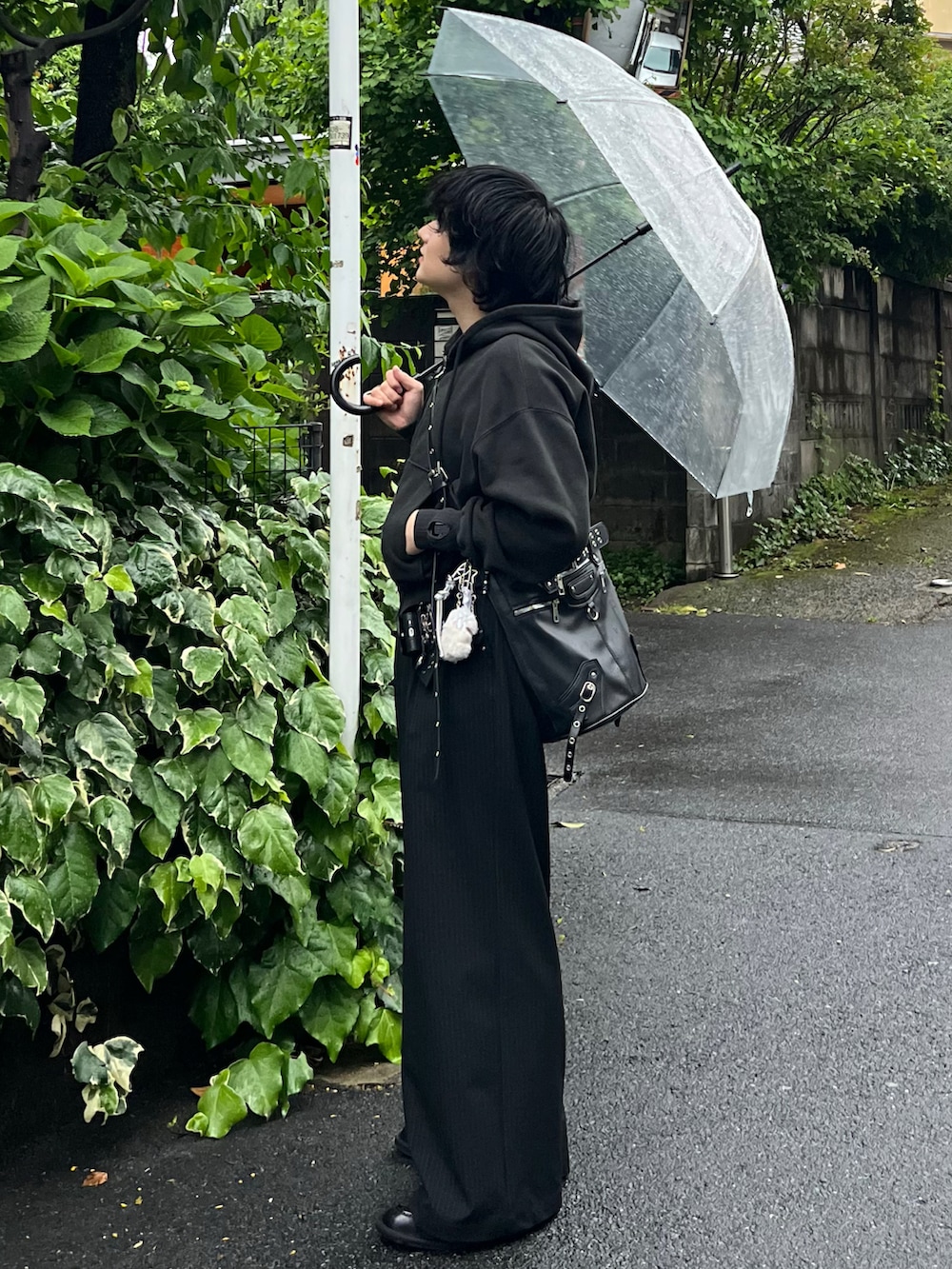 ブラック系のスラックス、ブラック系のパーカー、ブラック系のショルダーバッグを着用したメンズの春コーディネートの2枚目の写真