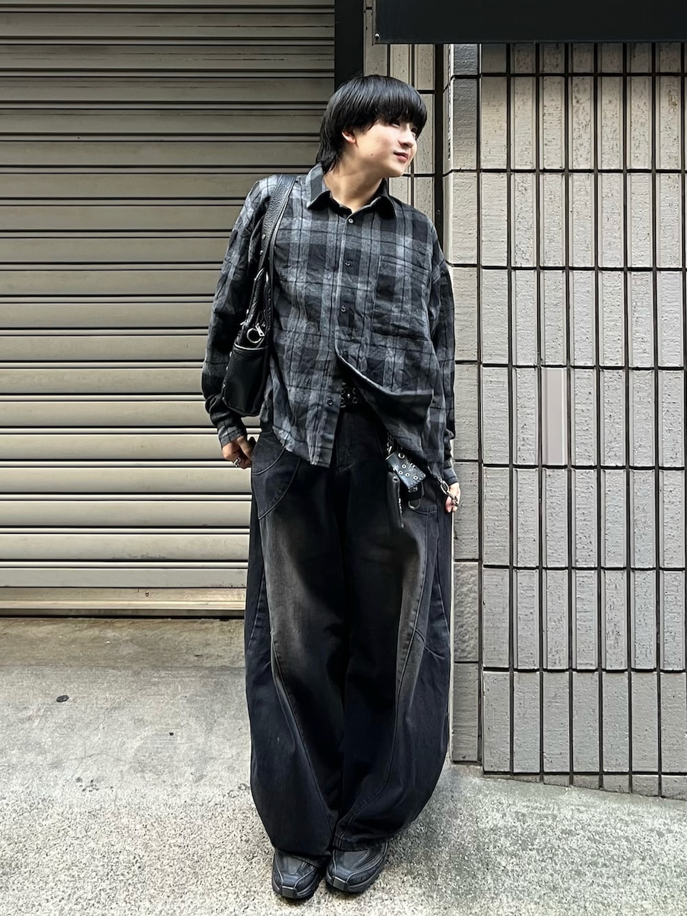 ブラック系のデニムパンツ、ブラック系のシャツ/ブラウス、ブラック系のスニーカーを着用したメンズの秋コーディネートの3枚目の写真