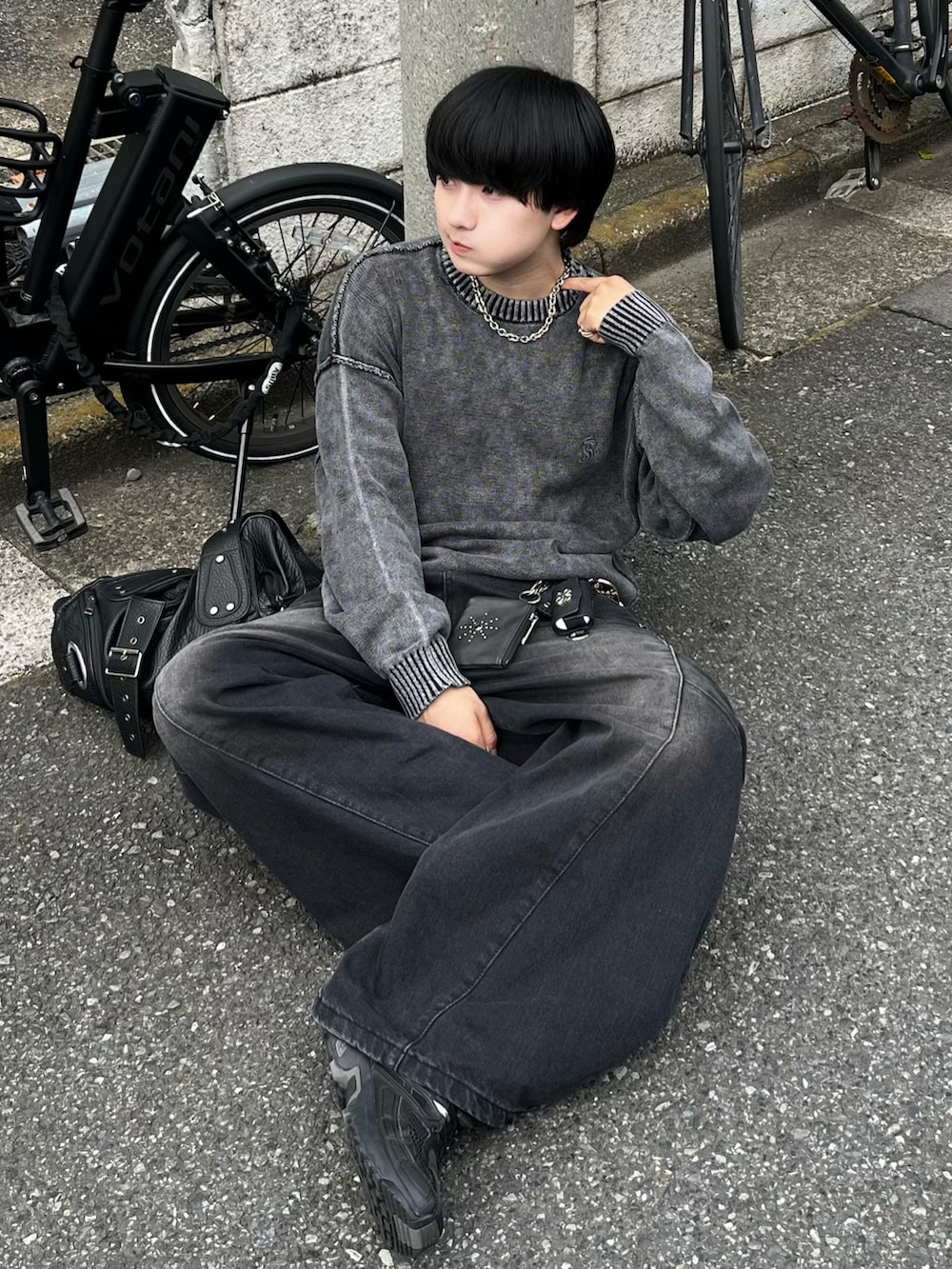 ブラック系のデニムパンツ、ブラック系のニット/セーター、ブラック系のショルダーバッグを着用したメンズの夏コーディネートの2枚目の写真