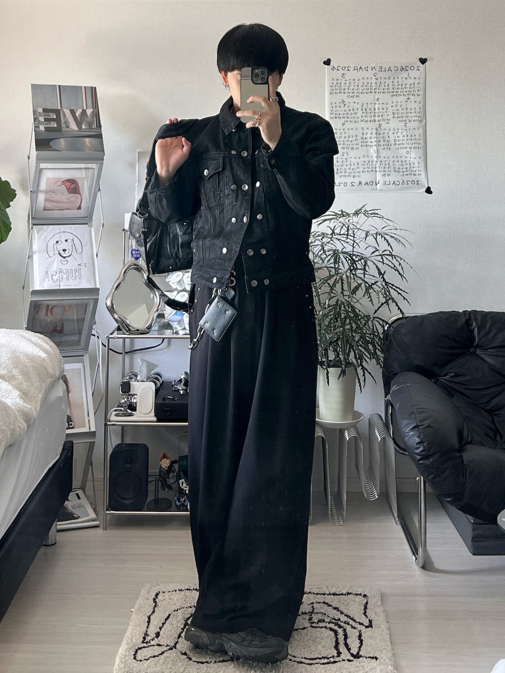 ブラック系のデニムジャケット、ブラック系のスラックス、ブラック系のショルダーバッグを着用したメンズの春コーディネートの2枚目の写真