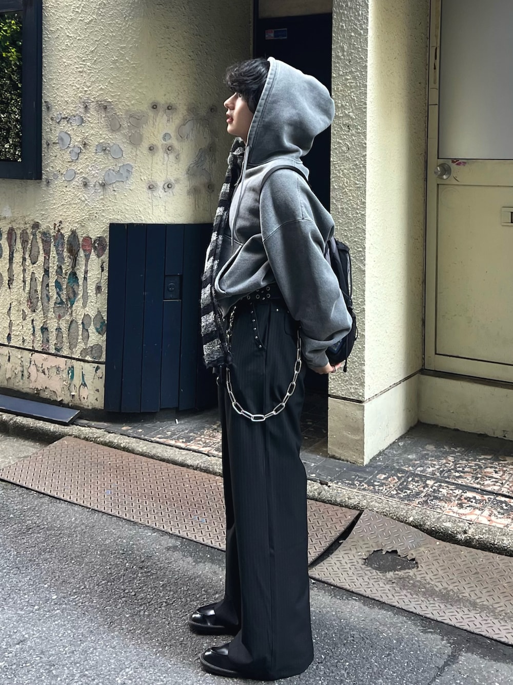 ブラック系のスラックス、グレー系のパーカー、ブラック系のドレスシューズを着用したメンズの春コーディネートの3枚目の写真