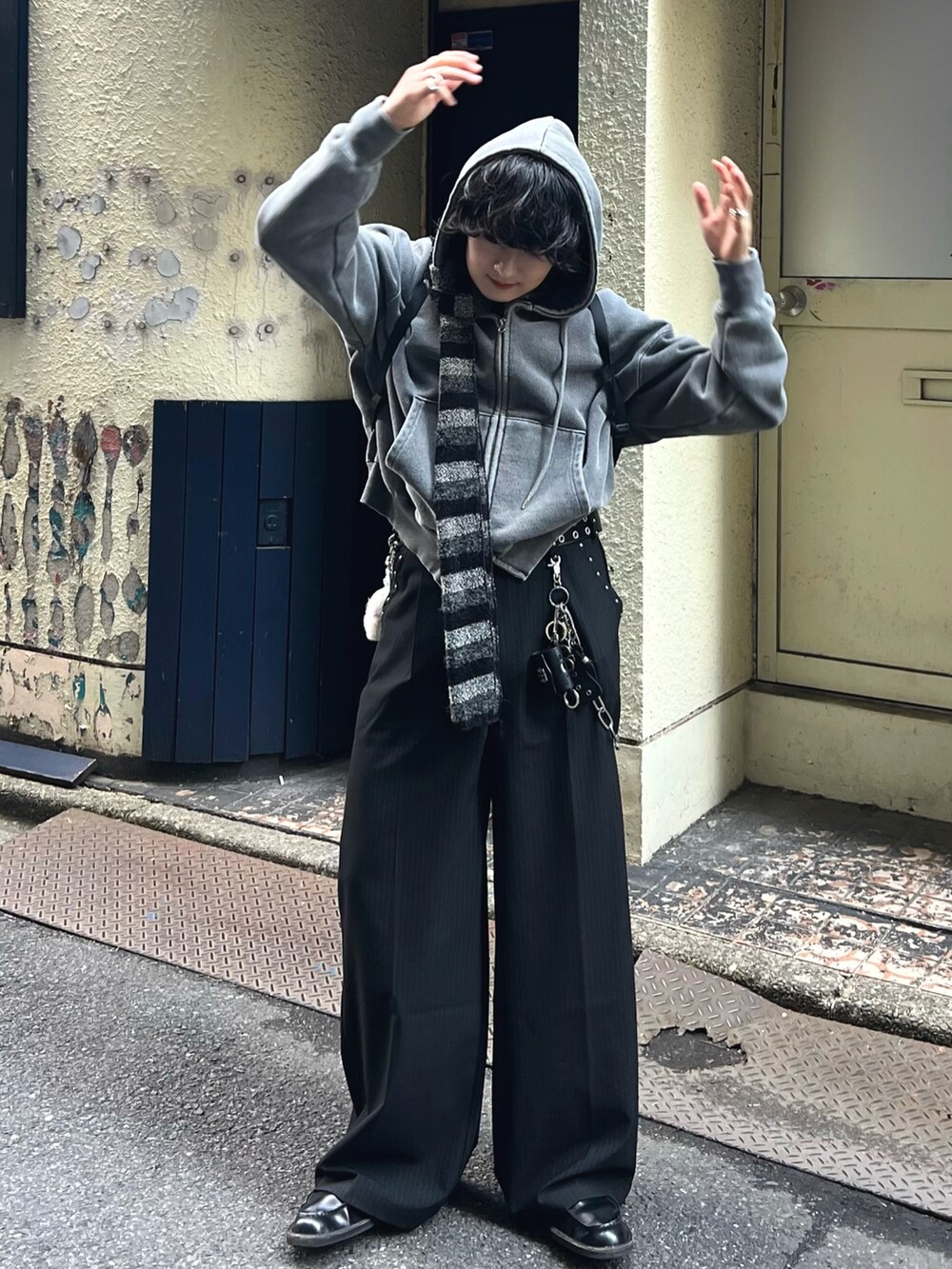 ブラック系のスラックス、グレー系のパーカー、ブラック系のドレスシューズを着用したメンズの春コーディネートの2枚目の写真