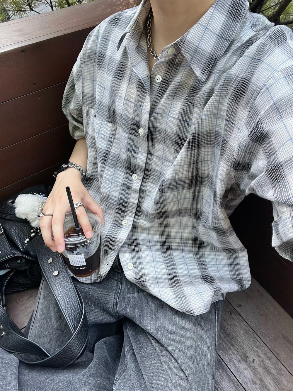 ブラック系のショルダーバッグ、ブラック系のスニーカー、ブラック系のデニムパンツを着用したメンズの夏コーディネートの2枚目の写真