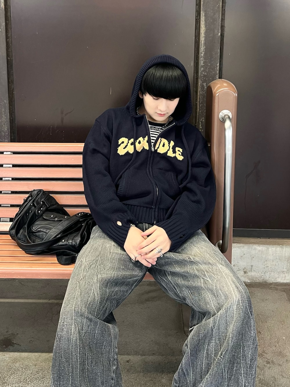 レッド系のパーカー、ブラック系のTシャツ/カットソー、ブラック系のデニムパンツを着用したメンズの春コーディネートの2枚目の写真