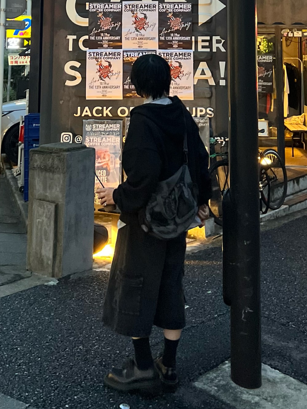 ブラック系のパーカー、グレー系のショルダーバッグ、ブラック系のデニムパンツを着用したメンズの秋コーディネートの3枚目の写真