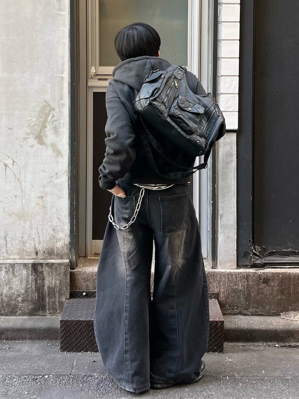 ブラック系のパーカー、ブラック系のTシャツ/カットソー、ブラック系のデニムパンツを着用したメンズの春コーディネートの3枚目の写真