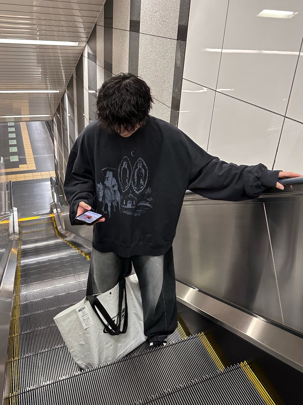 ブラック系のデニムパンツ、ブラック系のスニーカー、ブラック系のスウェットを着用したメンズの秋コーディネートの2枚目の写真